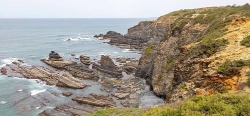 Rocky rugged coastline near fishing port village of Azenha do Mar, Alentejo Littoral, Portugal,