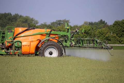 A farmer from the Schmitt vegetable farm in Hockenheim drives his tractor with a crop protection