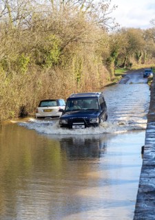 Land Rover Discovery Td5 vehicle driving through flood water at Kellaways, Wiltshire, England, UK