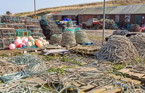 Fishing ropes, lobster pots and equipment on quayside Holy Island, Lindisfarne, Northumberland,