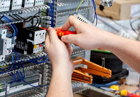 An electronics apprentice assembles a motor protection relay at a Deutsche Bahn training centre,