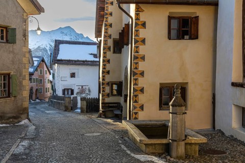 Historic houses, sgraffito, facade decorations, historic village, mountain peaks with snow, winter,