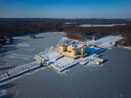 Moritzburg Castle on the castle island surrounded by the frozen castle pond, Moritzburg, Saxony,