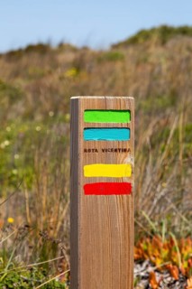Footpath marker way mark sign painted in green, blue, yellow and red stripes for the Ruta Vicentina