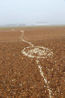 Coastal fog adds mystery to a line of white shells crossing pebble beach, Shingle Street, Suffolk,