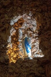 Statue of Blessed Virgin Mary standing in rock grotto ichurch of Igreja de Santiago, Tavira,