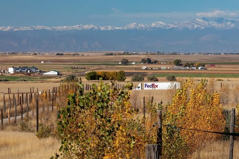 Keenesburg, Colorado, A FedEx truck on a rural road on Colorado's eastern plains, with the Rocky