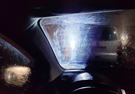 View from the car in dangerously poor visibility at night with rain and blinding backlight,