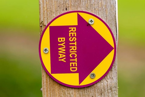 Macro close up of Restricted Byway sign on fencepost, Sutton, Suffolk, UK
