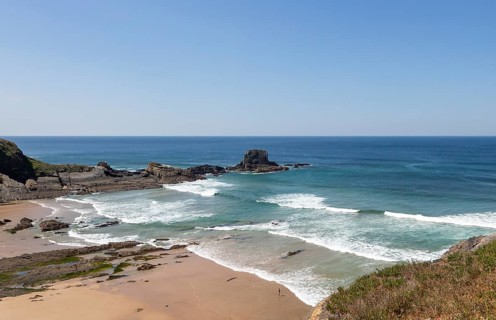 Sandy Carvalhal beach in bay between rocky headlands at Parque Natural do Sudoeste Alentejano e