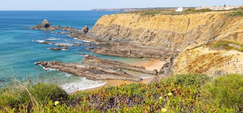 Rocky coastal landscape Praia dos Alteirinhos beach in bay with rocky headland part of Parque