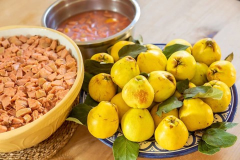 Bowls of quince fruit from garden and chopped fruits prepared for making jam jelly, UK
