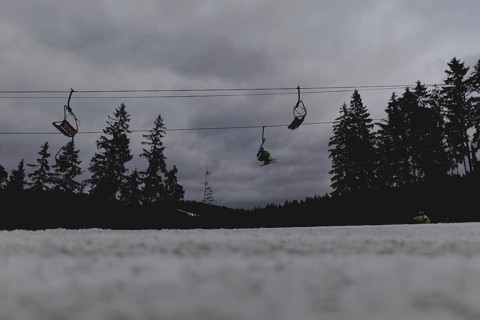 Skiers ride a chairlift, taken on a ski slope in the Jizera Mountains ski area near Albrechtice v