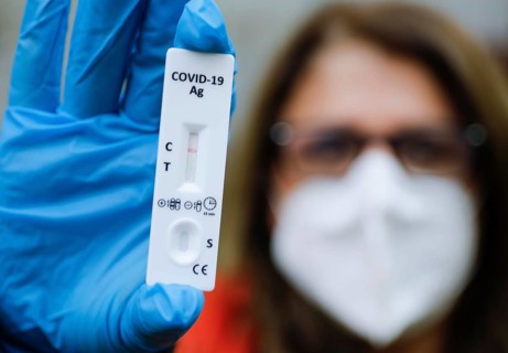 A woman with FFP2 mask shows a negative Corona rapid test, Berlin, 11.03.2021