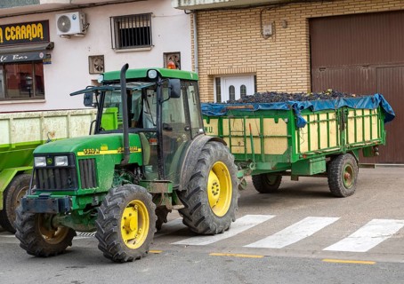John Deere tractor with trailer of freshly harvested grapes, San Asensio, La Rioja Alta, Spain,