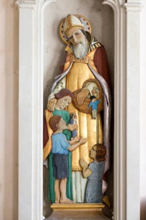 Sculpture statue of Saint Nicholas with children inside village parish church of Saint Nicholas,