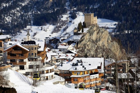 Ladis in winter, the ski piste in the foreground and the village with Laudegg Castle in the