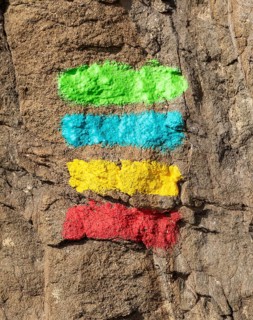 Footpath marker way mark sign painted in green, blue, yellow and red stripes for the Ruta Vicentina