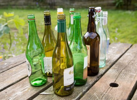 Empty glass bottles standing on a table outdoors in sunshine, UK