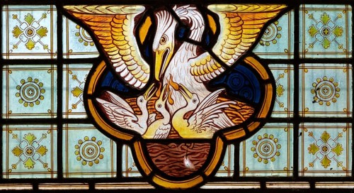 Stained glass window Bedingfield church, Suffolk, England, UK c 1878, detail of pelican feeding its