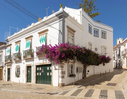 Bougainvillea plant in flower growing on whitewashed house old town, Tavira, Algarve, Portugal,