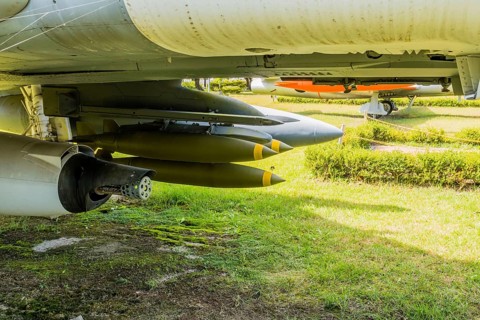 Battery of missiles and front of machine gun mounted under military jet aircraft on display in