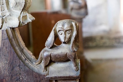 Carved medieval bench ends at All Saints church, South Elmham, Suffolk, England, UK, a dog with