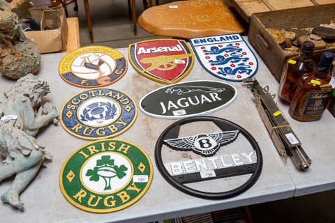 Replica cast iron metal plaques on table at auction, England, UK