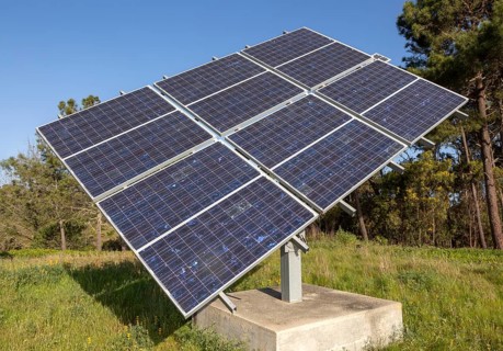 Solar panel array in rural location of field in countryside providing domestic energy near village