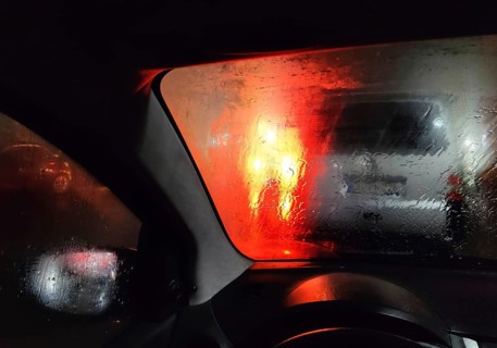 View from the car in dangerously poor visibility at night with rain and blinding backlight,