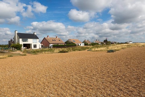 On the left is Ronina, former MOD house redesigned by Casswell Bank architects on beach at Shingle