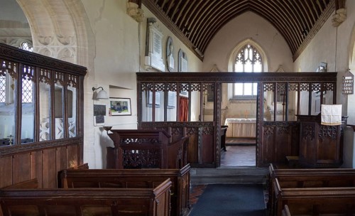 Wooden chancel screen dating from 15th, 16th century looking down to altar and east window inside