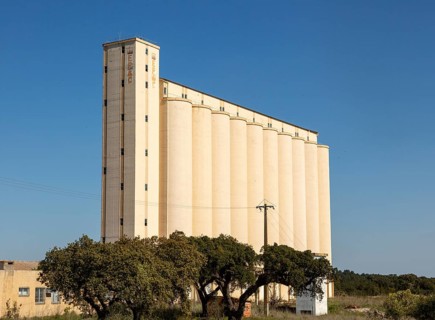 Large EPAC grain cereal silo in arable farming area standing tall against deep blue sky, near