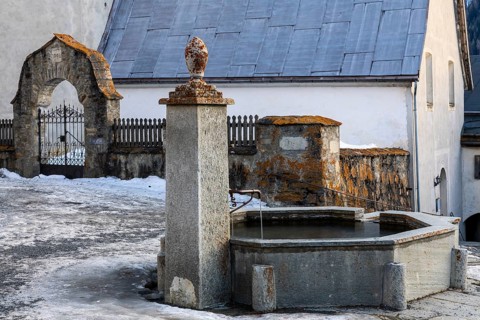 Stone fountain in front of the church, Guarda, Engadin, Grisons, Switzerland, Europe