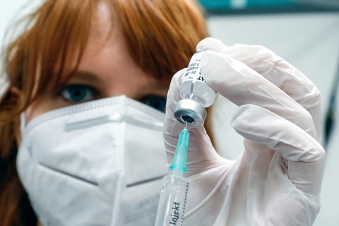 Drawing up a syringe with the Biontech Pfizer active ingredient Comirnaty against Covid19 in a