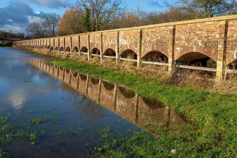Arches of Maud Heath's causeway reflected by flood water, Kellaways, Wiltshire, England, UK