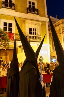 Nazarenos with black robes and typical pointed bonnets, insignia, Semana Santa, procession, night