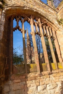 Steeple of Holy Trinity church seen through bombed out windows of old cathedral, Coventry, England,