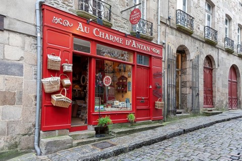 Traditional shop with red facade and baskets on a cobbled pavement, Dinan, Brittany, France, Europe