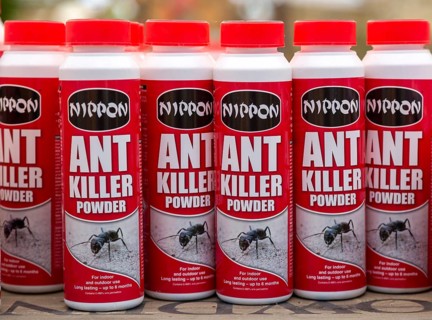 Plastic containers of Nippon brand ant killer powder on shelf display in garden centre, UK