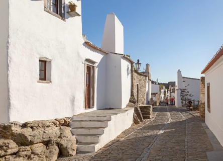 Historic cobbled street whitewashed buildings walled hilltop village Monsaraz, Alto Alentejo,