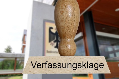 Symbolic image of a constitutional complaint: in the foreground a stamp, in the background the