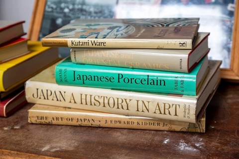 Books on Japanese art an ceramics on display in house clearance auction sale room, UK