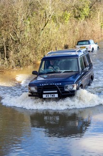 Land Rover Discovery Td5 vehicle driving through flood water at Kellaways, Wiltshire, England, UK