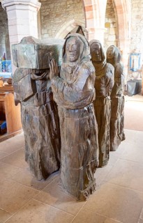 The Journey Sculpture of monks carrying body of Saint Cuthbert by Fenwick Lawson 1999 Holy Island,