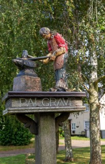 Model of blacksmith working on village sign for Palgrave, Suffolk, England, UK