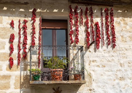 Strings of red peppers chilies drying outside house, village of Elceigo, Alava, Basque Country,