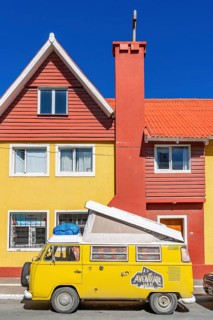 Yellow Volkswagen van in retro style in front of a yellow and red house, Ushuaia, Tierra del Fuego