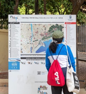 Person looking at plan map of city centre of Malaga, Andalusia, Spain showing locations of main