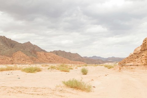 Desert, red mountains, rocks and cloudy sky. Egypt, the Sinai Peninsula, Dahab